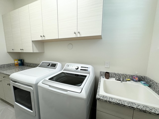 washroom with cabinets, sink, and independent washer and dryer