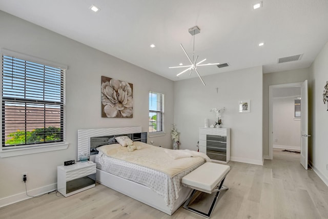 bedroom featuring an inviting chandelier and light wood-type flooring