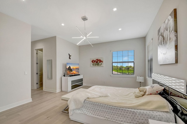 bedroom with a notable chandelier and light hardwood / wood-style floors