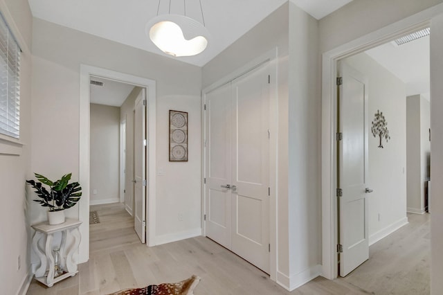 corridor with light hardwood / wood-style floors