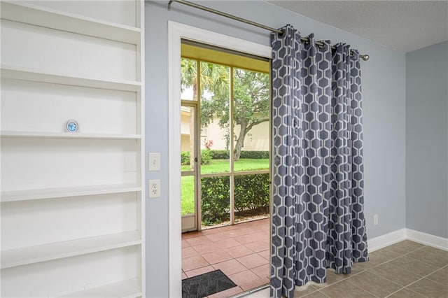 doorway to outside featuring tile patterned floors and built in shelves