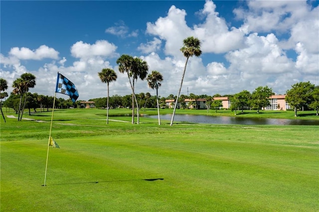 surrounding community with a water view and a lawn