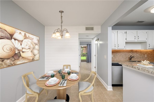 tiled dining room featuring a chandelier and sink