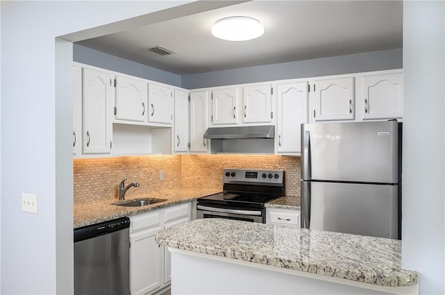 kitchen featuring tasteful backsplash, white cabinets, appliances with stainless steel finishes, and sink