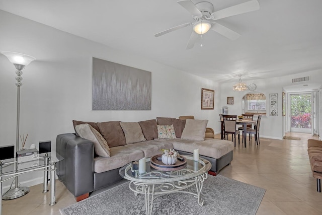 living area with visible vents, ceiling fan, baseboards, and light tile patterned floors