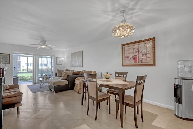 dining room with light tile patterned floors, baseboards, and ceiling fan with notable chandelier