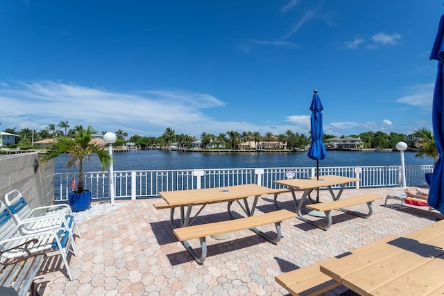 view of patio with a water view and outdoor dining space