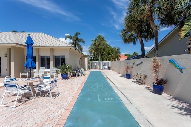 view of community featuring shuffleboard and fence