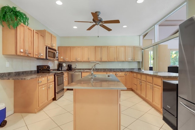 kitchen featuring a center island with sink, appliances with stainless steel finishes, light brown cabinets, a sink, and light tile patterned flooring