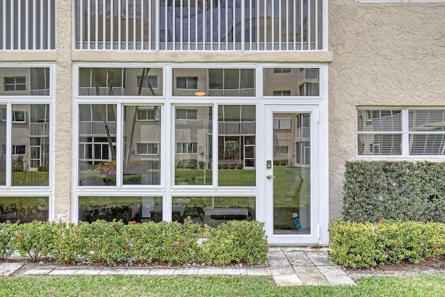 view of exterior entry featuring stucco siding