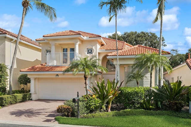 mediterranean / spanish house featuring a garage and a balcony