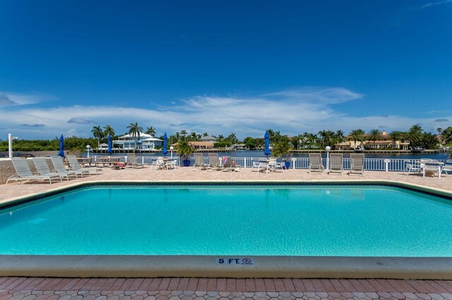 view of pool featuring a patio area and a water view