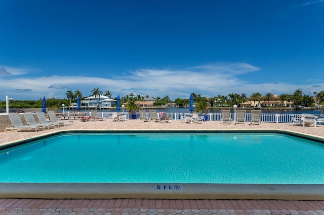 view of pool featuring a water view and a patio area