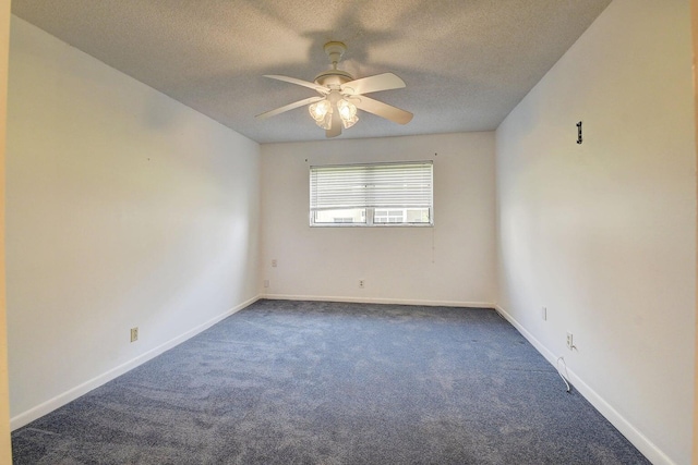 empty room featuring ceiling fan, dark carpet, and a textured ceiling