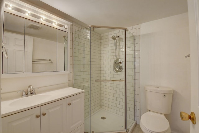 bathroom featuring vanity, a shower with door, and toilet