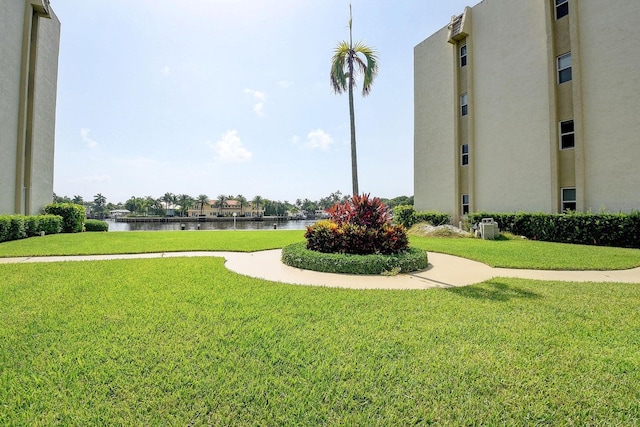 view of community featuring a water view and a yard