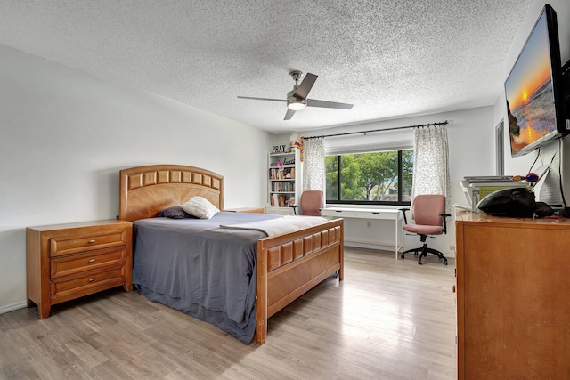 bedroom featuring ceiling fan, light hardwood / wood-style floors, and a textured ceiling