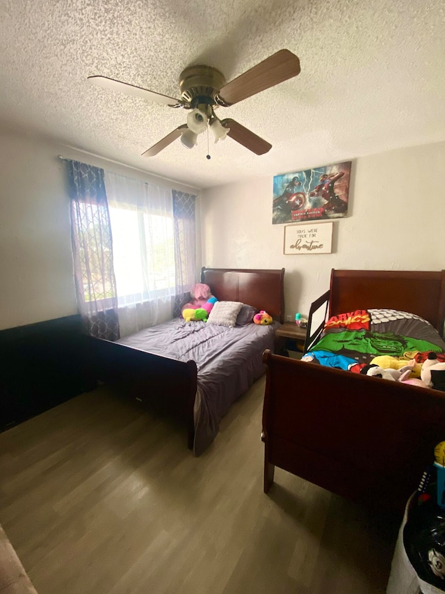 bedroom featuring hardwood / wood-style floors, ceiling fan, and a textured ceiling