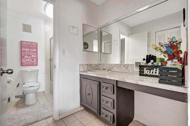 bathroom featuring vanity, toilet, a shower with shower door, and tile patterned flooring