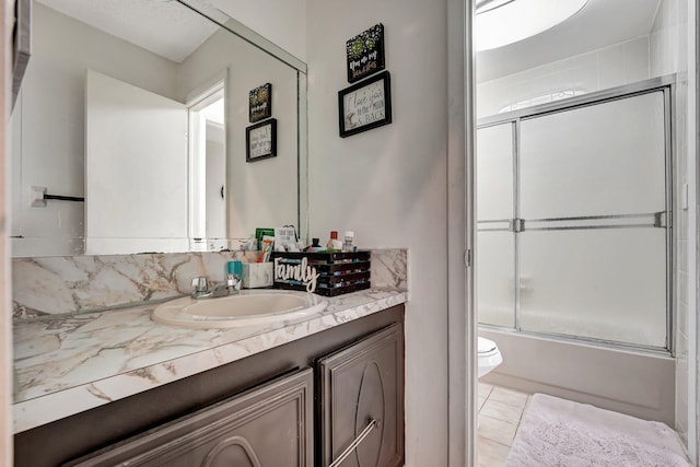 full bathroom with vanity, toilet, bath / shower combo with glass door, and tile patterned floors