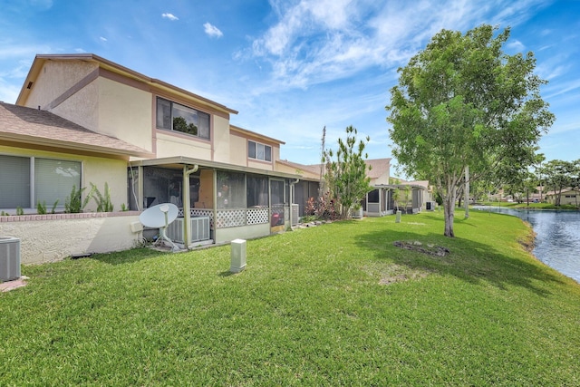 view of yard featuring a water view and a sunroom