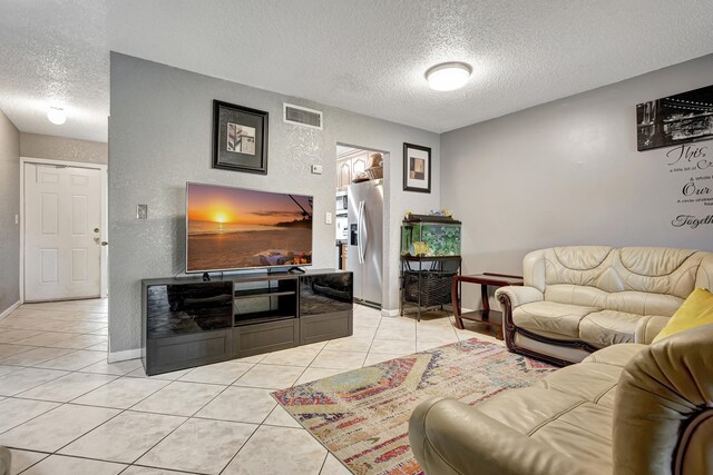 living room with a textured ceiling and light tile patterned floors