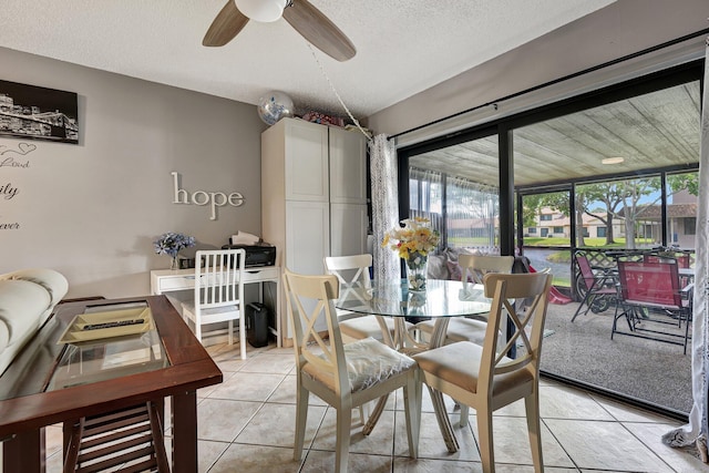 dining area with a textured ceiling, light tile patterned floors, and ceiling fan