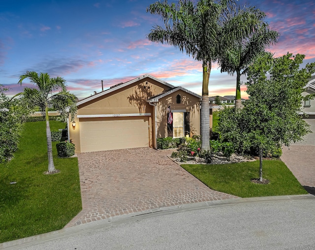 view of front of home featuring a garage and a yard