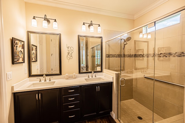 bathroom featuring dual bowl vanity, a shower with door, and ornamental molding