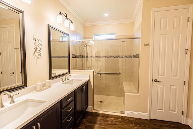 bathroom with crown molding, hardwood / wood-style floors, dual bowl vanity, and walk in shower