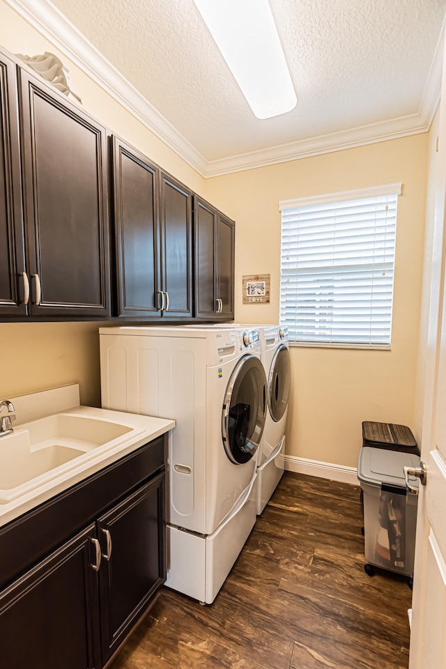 laundry room with crown molding, dark hardwood / wood-style flooring, cabinets, and separate washer and dryer