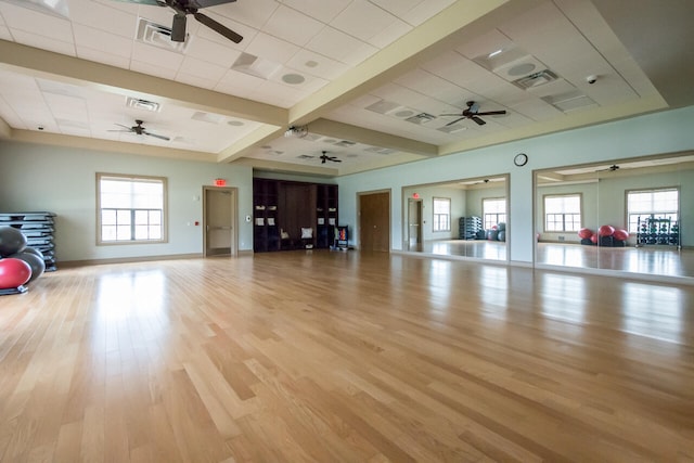 workout room with light hardwood / wood-style flooring, ceiling fan, and a healthy amount of sunlight