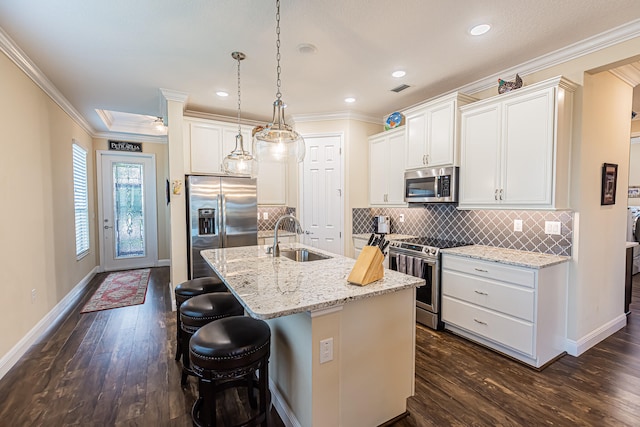 kitchen with appliances with stainless steel finishes, sink, dark hardwood / wood-style floors, an island with sink, and tasteful backsplash