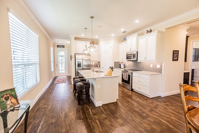 kitchen with dark wood-type flooring, stainless steel appliances, sink, and a healthy amount of sunlight