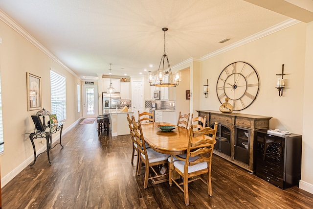 dining room featuring dark hardwood / wood-style floors, an inviting chandelier, and crown molding