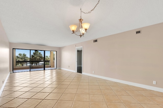 tiled empty room featuring an inviting chandelier and a textured ceiling