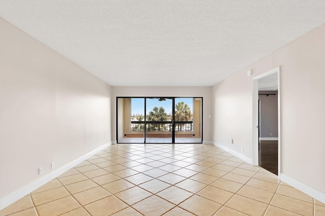 spare room with light tile patterned floors and a textured ceiling