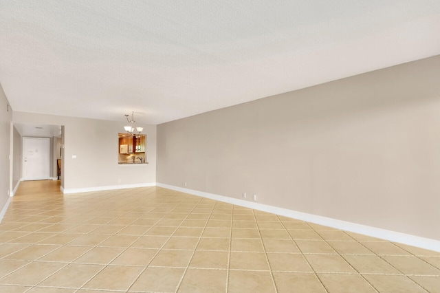 unfurnished room with an inviting chandelier and light tile patterned floors