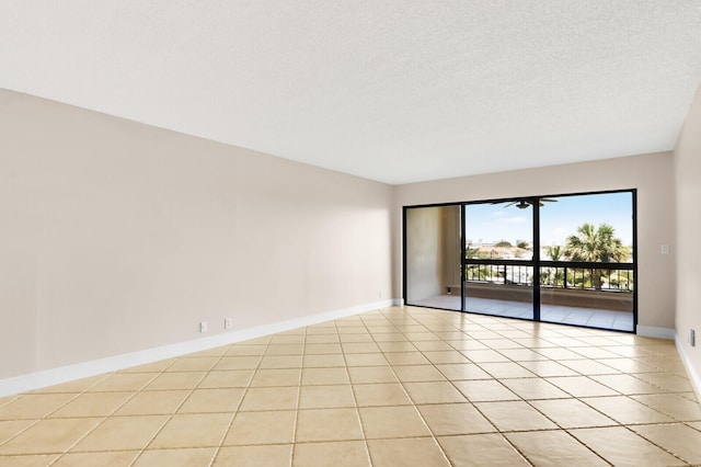 unfurnished room featuring a textured ceiling and light tile patterned floors