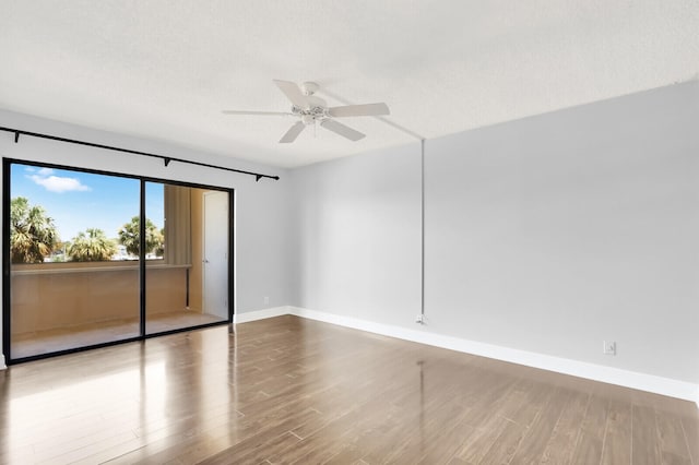 spare room featuring a textured ceiling, wood-type flooring, and ceiling fan