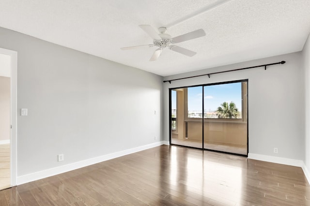 empty room with a textured ceiling, hardwood / wood-style flooring, and ceiling fan