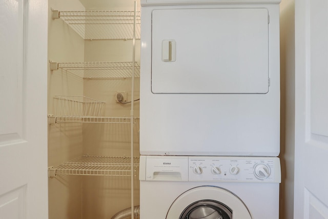 clothes washing area with stacked washer / dryer