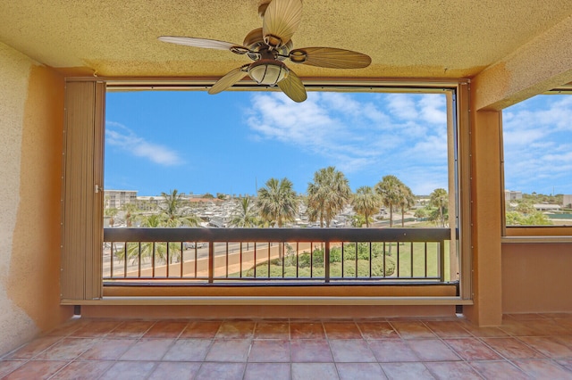 unfurnished sunroom featuring ceiling fan