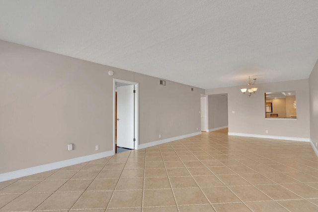 unfurnished living room with an inviting chandelier and light tile patterned floors