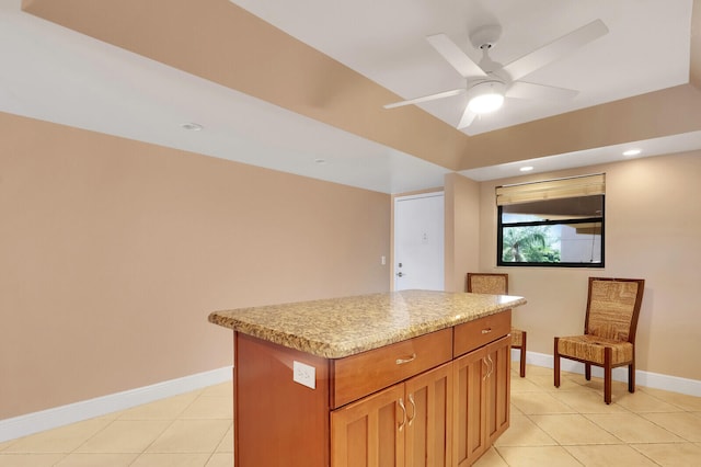 kitchen with light tile patterned floors, ceiling fan, and a kitchen island