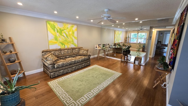 living room with a textured ceiling, ornamental molding, and hardwood / wood-style floors