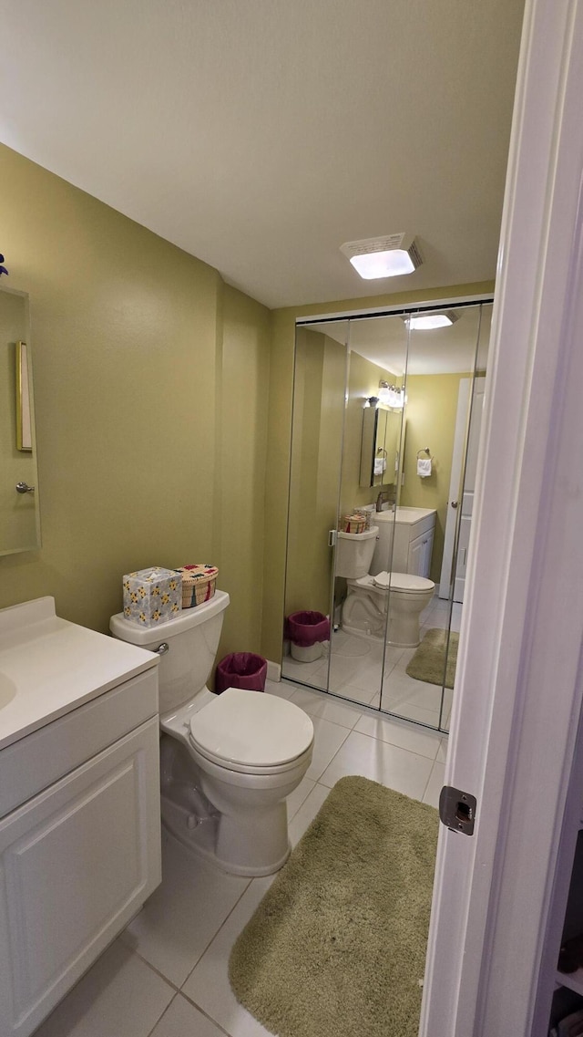 bathroom featuring toilet, vanity, and tile patterned flooring