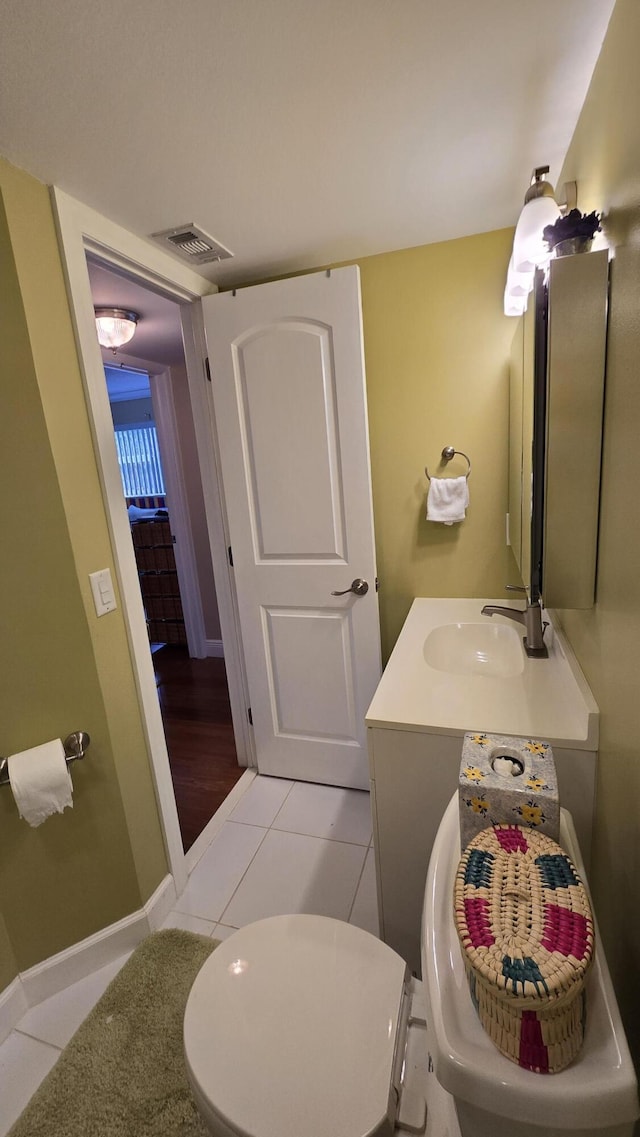 bathroom featuring toilet, vanity, and tile patterned flooring