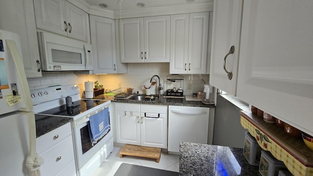 kitchen featuring white appliances, white cabinetry, decorative backsplash, sink, and light tile patterned floors