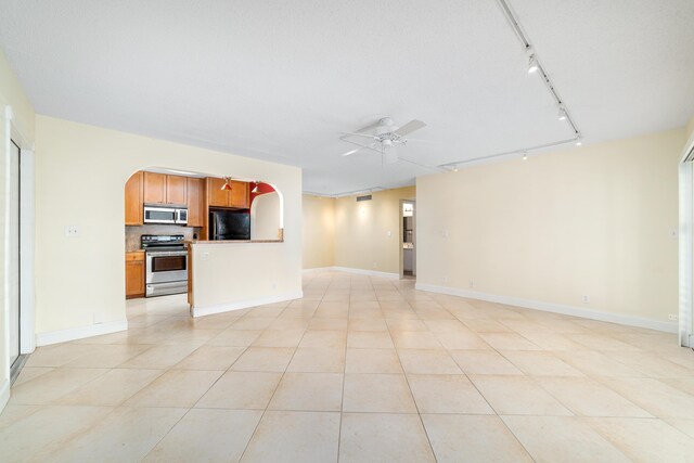 unfurnished living room with track lighting, light tile patterned floors, and ceiling fan